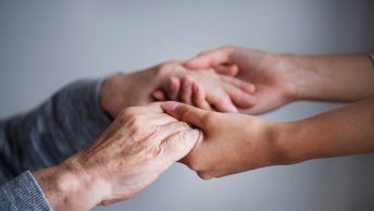 Persona con parkinson coge de las manos a otra