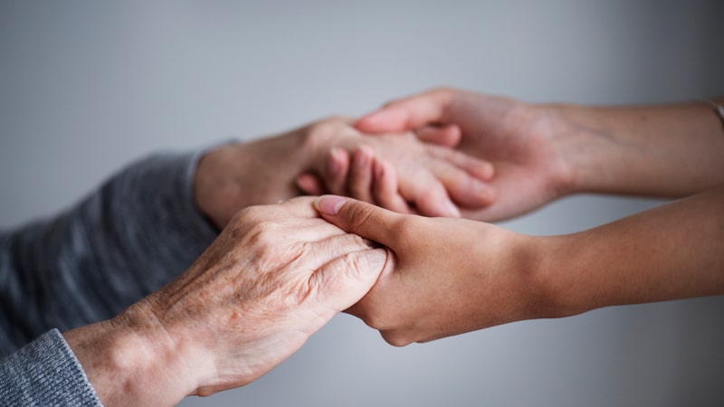 Persona con parkinson coge de las manos a otra