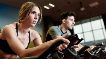 Deportistas pedaleando en ciclo indoor al ritmo de la música