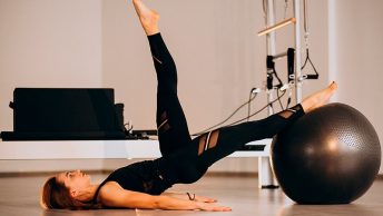 Mujer hace el puente sobre los hombros en pilates