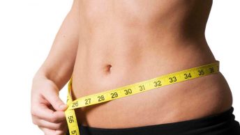 Mujer midiéndose la barriga