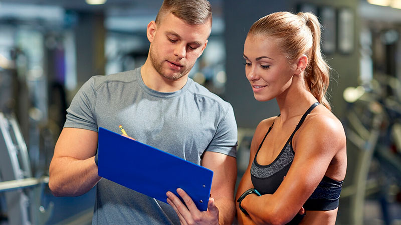 El entrenador personal y la valoración de la condición física 1 Entrenador personal indicando a clienta