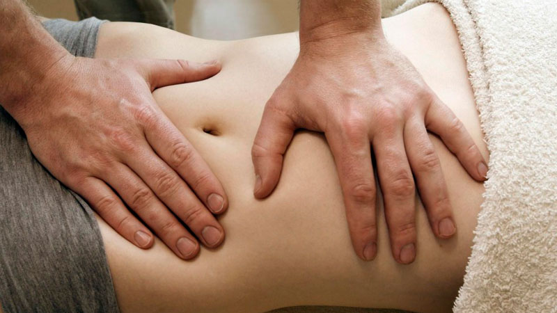 Terapeuta haciendo osteopatía visceral