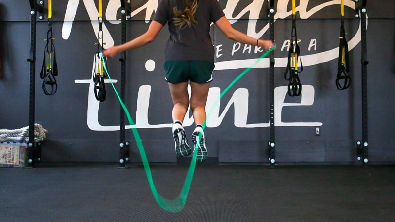 Chica salta a la comba en el gimnasio