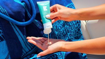 Mujer vertiendo crema solar en su mano