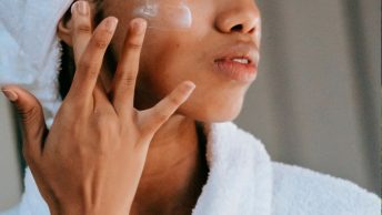 Mujer esparciendo crema en su cara