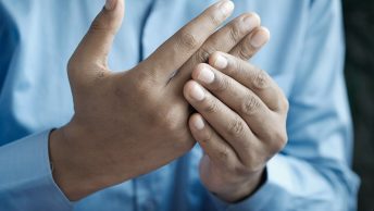 Hombre se toca los dedos de la mano
