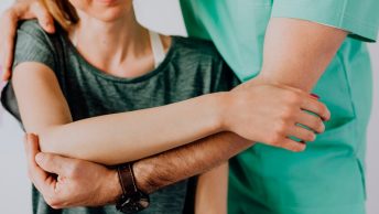 Mujer en consulta de osteopatía por dolor de hombro