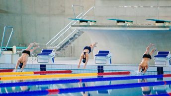 Nadadores se lanzan a una piscina cubierta