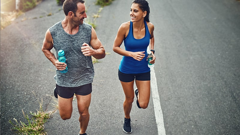 Estrategias de hidratación para deportes de larga duración 1 Dos corredores se hidratan durante una carrera